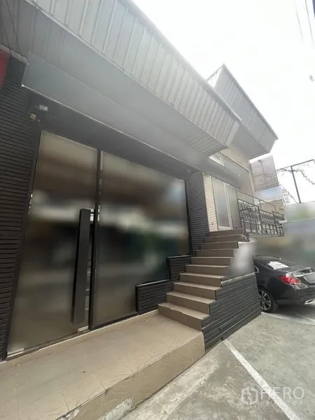 Retail Space for rent in Watthana, Bangkok - Street-front retail unit exterior with wide glass doors, side steps, and on-site parking bay.