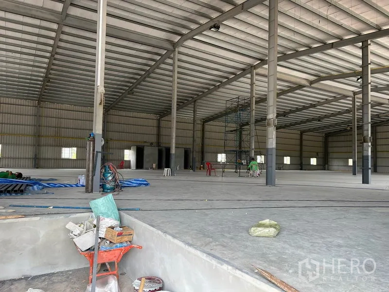 Warehouse for rent in Lat Krabang, Bangkok - Spacious warehouse interior with high clear-span steel frame and smooth concrete floor under fit-out.
