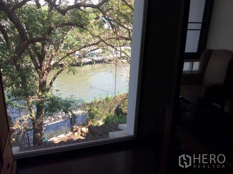 Townhouse for rent or sale in Suan Luang, Bangkok - Window view over a tree-lined canal and footpath.