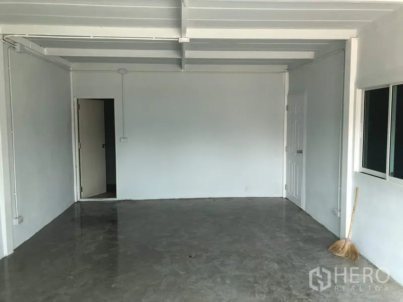 Factory for rent in Khlong Luang, Pathum Thani - Empty office room with white walls, window and concrete floor inside the factory.