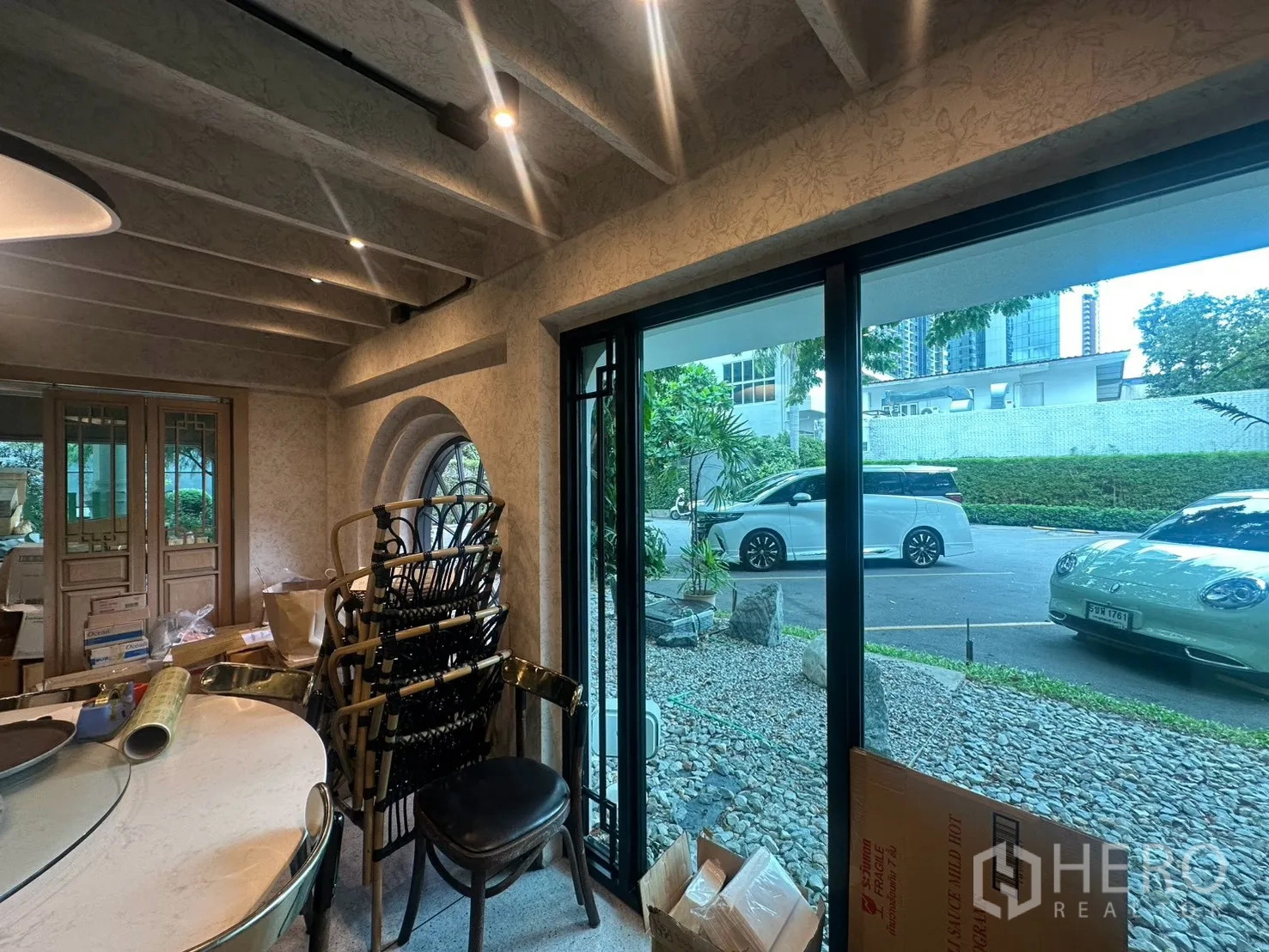 独栋房屋 for rent in Watthana, Bangkok - 室内透过大推拉窗可见停车区域。
