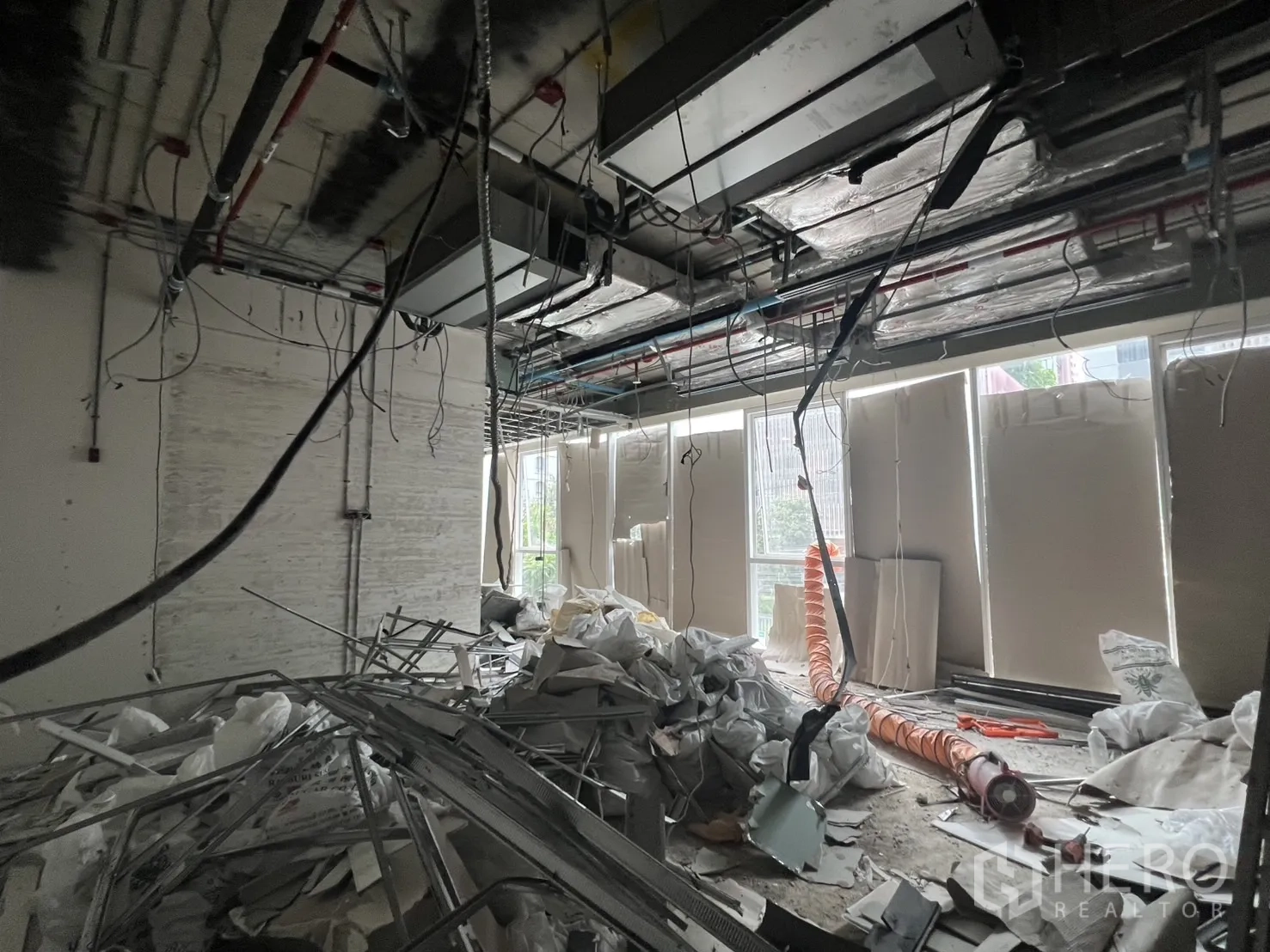 Retail Space for rent - Raw interior space with large windows, exposed services and construction materials.