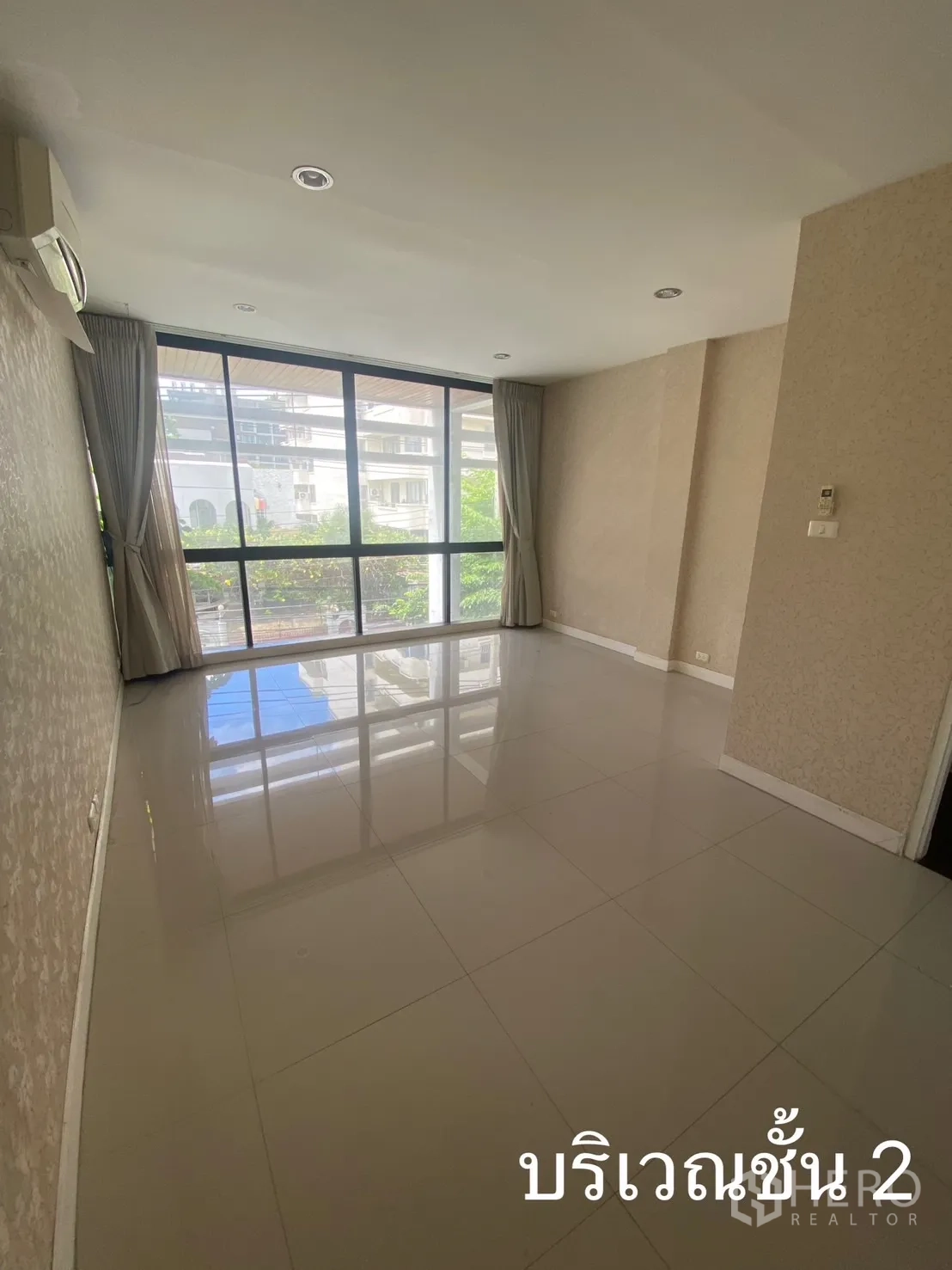 Shophouse for rent in Watthana, Bangkok - Bright room with full-height glazing and curtains overlooking neighborhood.