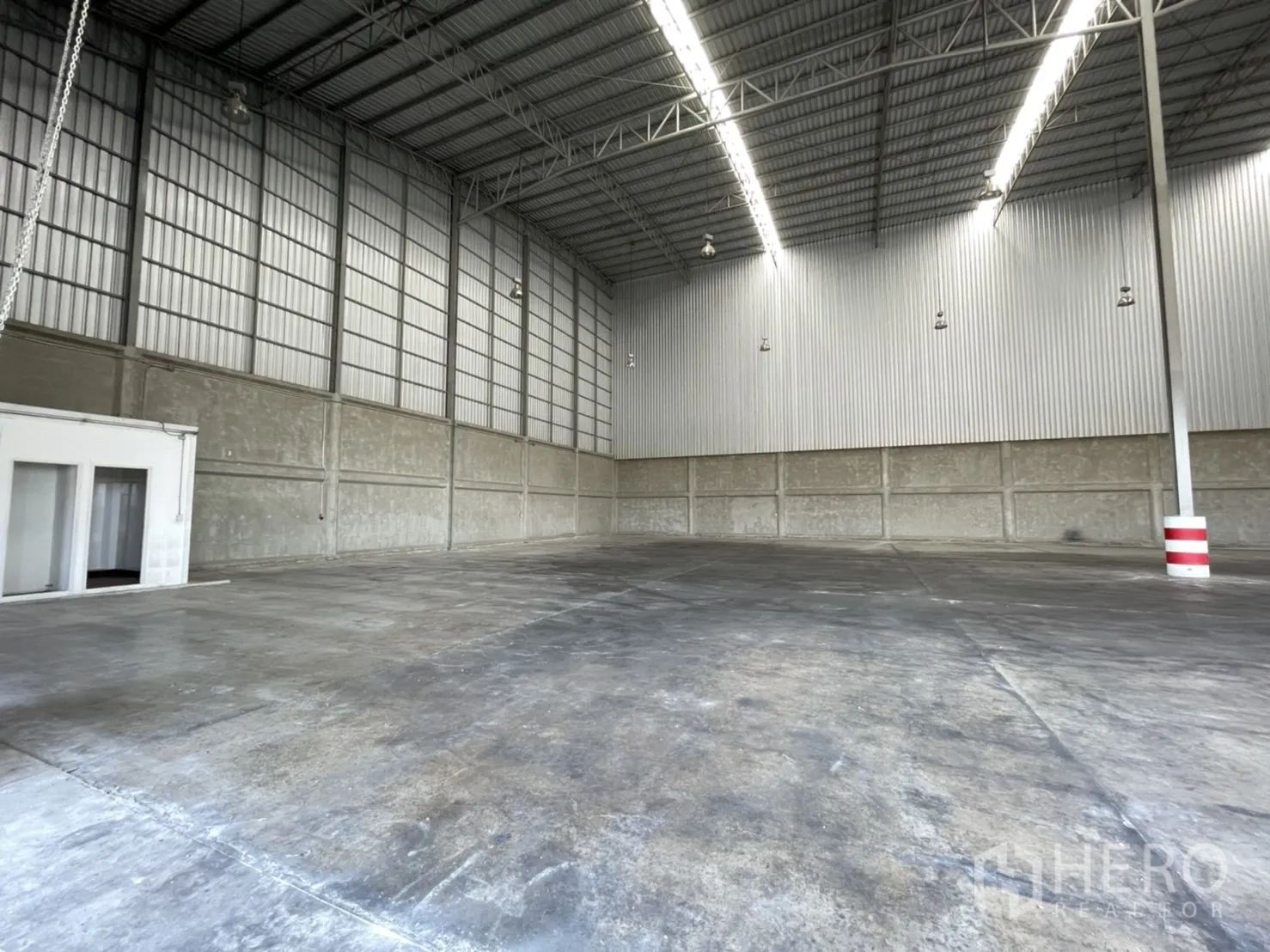 Warehouse for rent in Lam Luk Ka, Pathum Thani - Wide, column-free warehouse with polished concrete floor and bright linear skylight fixtures.