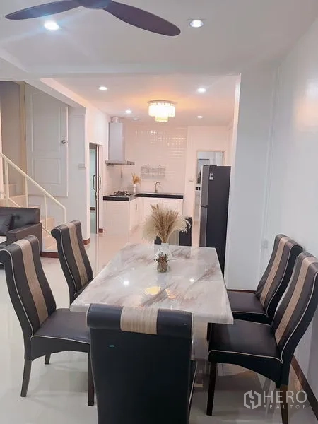 Townhouse for rent in Huai Khwang, Bangkok - Dining space leading to the white kitchen and staircase to upper floor.