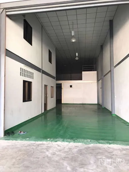 Factory for rent in Bang Phli, Samut Prakan - Open factory interior viewed from the shutter entrance with high ceiling.
