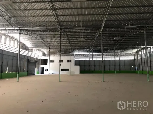 Warehouse for rent in Lat Krabang, Bangkok - Expansive high-roof warehouse interior with steel trusses, skylights and a built-in white office block in Lat Krabang.
