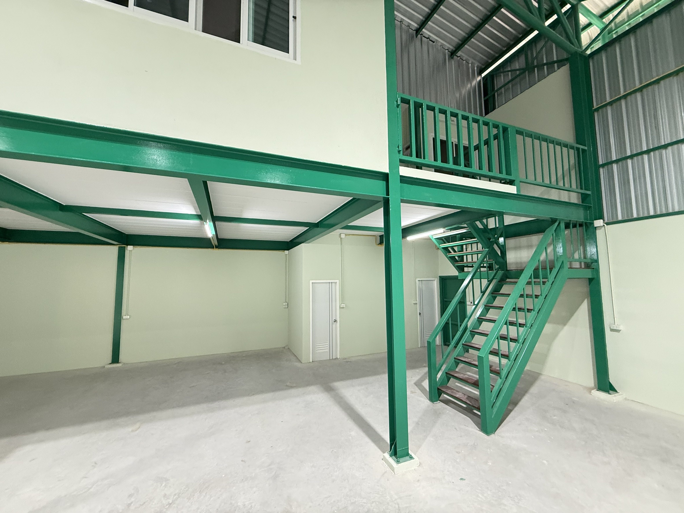 Warehouse for rent in Lat Krabang, Bangkok - Close-up of green steel stairs and mezzanine platform for office or extra storage.