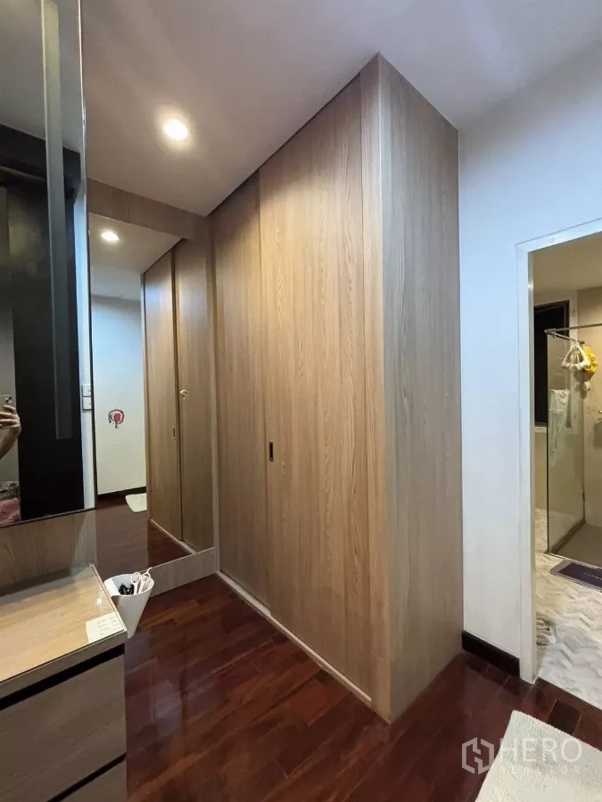 Detached House for rent in Bang Kapi, Bangkok - Dressing corridor with wooden closets and vanity near the bathroom.