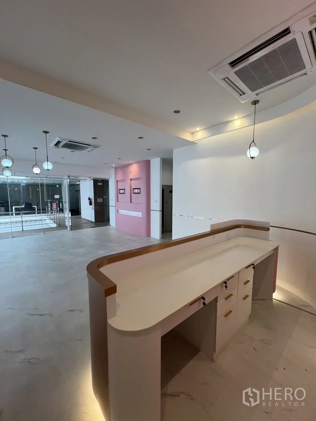 Retail Space for rent in Watthana, Bangkok - Curved built-in reception counter with overhead lighting in an open-plan retail area.