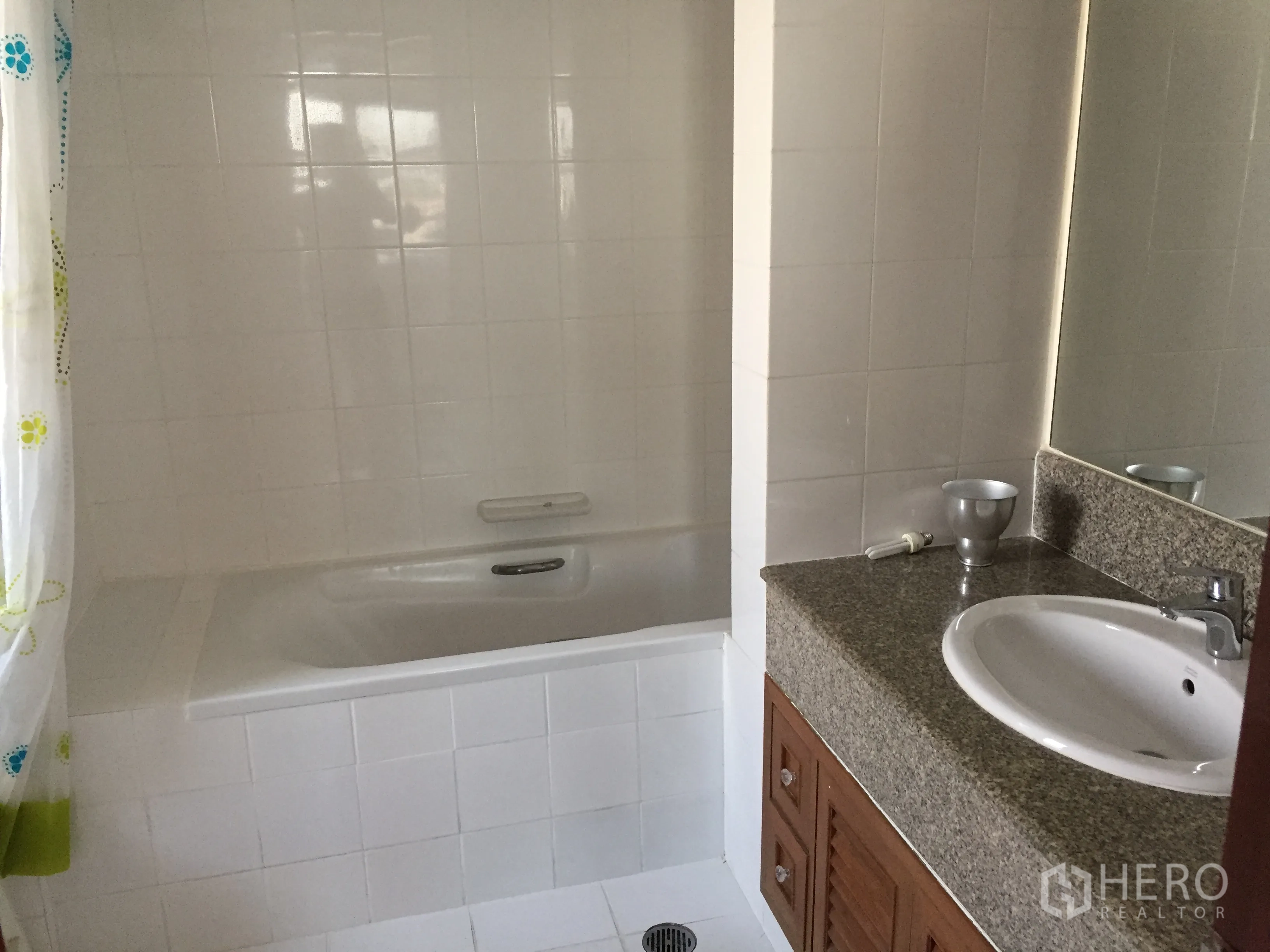 Condominium for rent in Watthana, Bangkok - Clean tiled bathroom with built-in bathtub, large mirror and granite vanity.