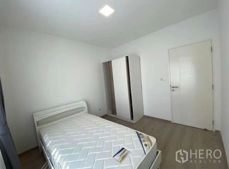 Townhouse for rent in Bang Phli, Samut Prakan - Second bedroom with wardrobe, white door and wood-look flooring.