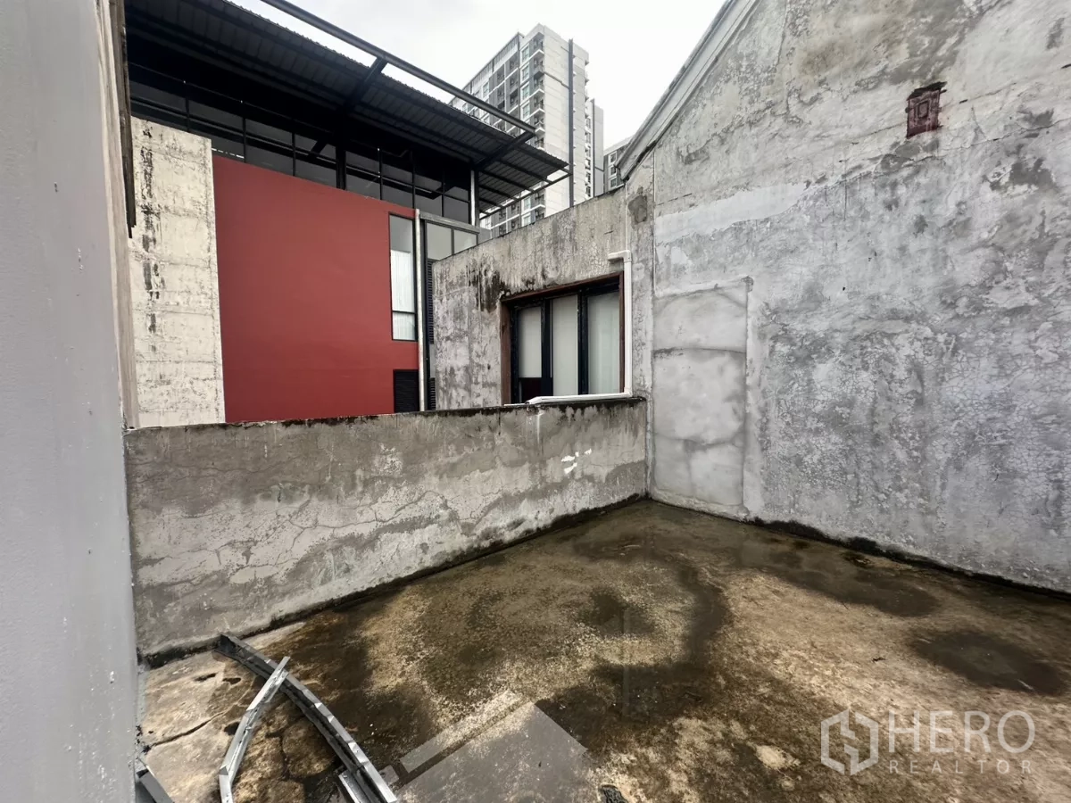 Home Office for rent in Pathum Wan, Bangkok - Private rooftop terrace with rough concrete surface and low parapet walls, city buildings nearby.