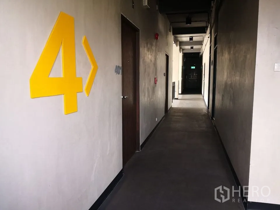 Office Space for rent in Phra Khanong, Bangkok - Fourth-floor corridor with large yellow number 4, wooden doors and ceiling lights