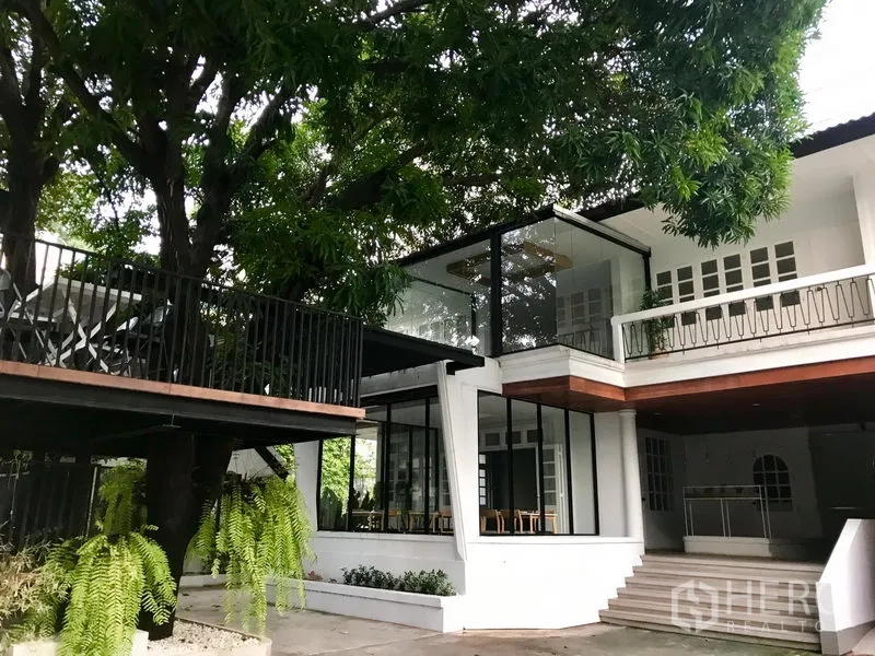 Retail Space for rent in Bang Rak, Bangkok - Garden-front retail space featuring a glass-enclosed room, terrace deck and broad entry steps under a large tree canopy.