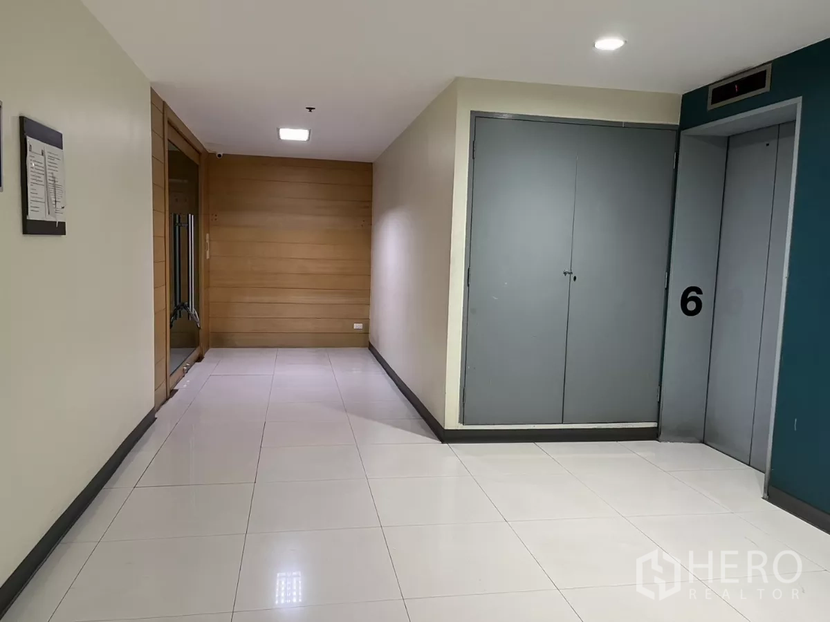 Office Space for rent in Bang Rak, Bangkok - Elevator lobby on the office level with tiled floors and wood accent wall.
