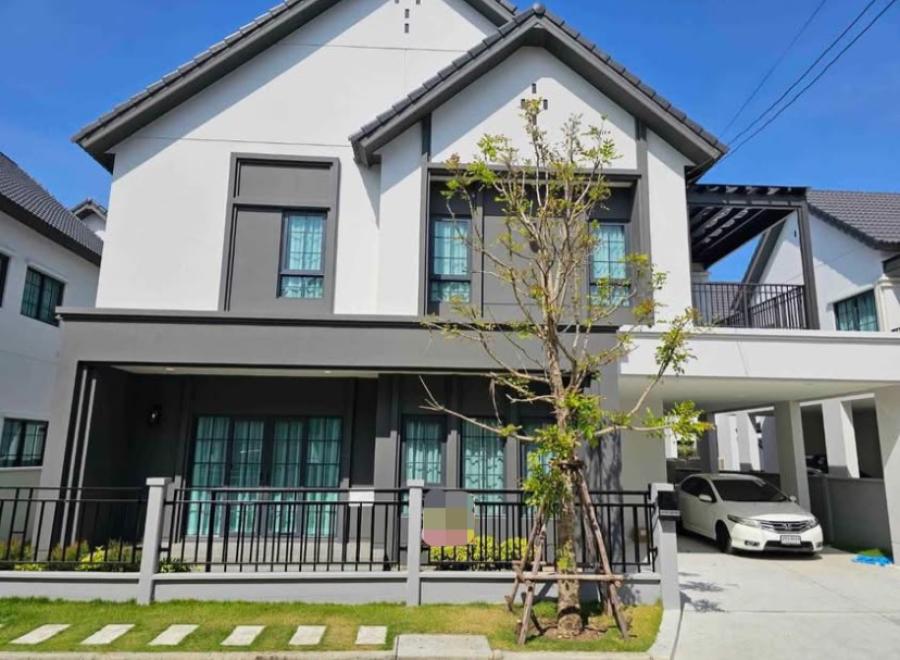 Detached House for rent in Bang Phli, Samut Prakan - Modern two‑storey detached house facade with fenced front lawn and covered carport under clear sky.