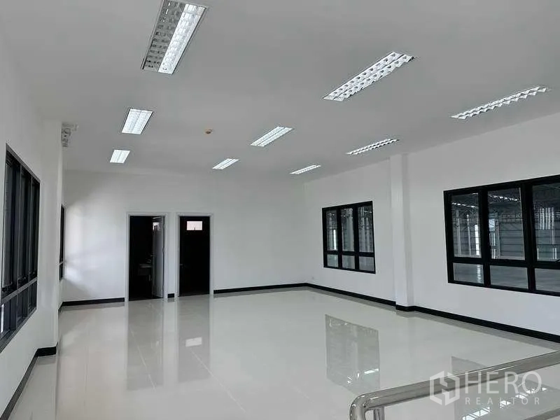Factory for rent in Bang Phli, Samut Prakan - Bright open-plan office room with tiled floors and multiple windows overlooking the warehouse.