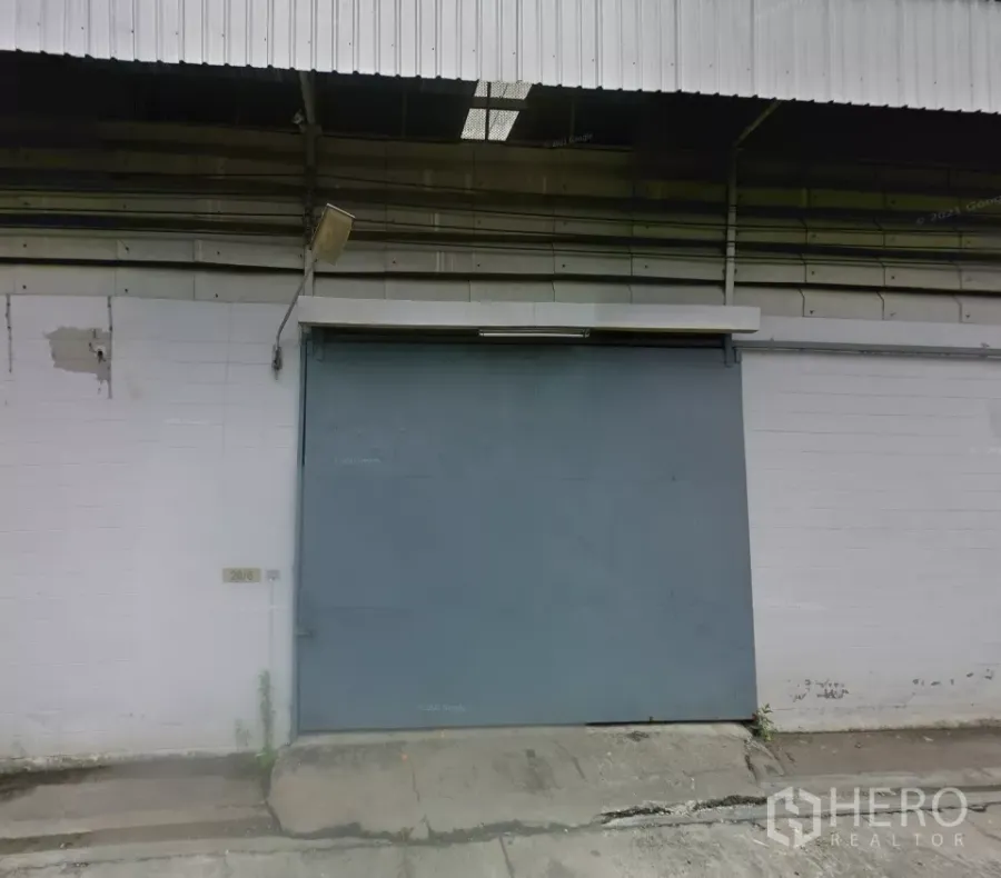 货栈 出租在Bang Phli, Samut Prakan - 邦披工业仓库外立面，配大尺寸钢制推拉门、金属屋顶与混凝土装卸坡道。
