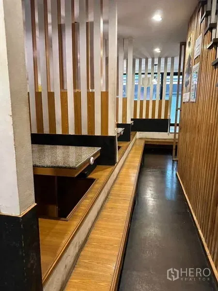 Shophouse for rent or sale in Watthana, Bangkok - Private booth seating with wood‑slat partitions and raised platforms for dining.