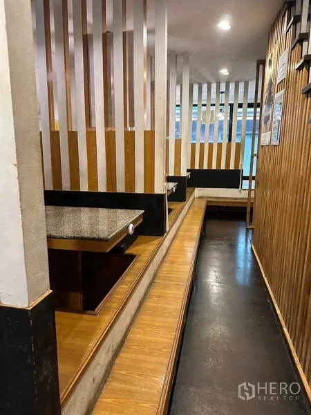 Shophouse for rent or sale in Watthana, Bangkok - Private booth seating with wood‑slat partitions and raised platforms for dining.