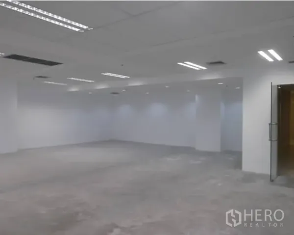 Office Space for rent - Empty open-plan office floor with white walls, drop ceiling lights and air-conditioning vents.