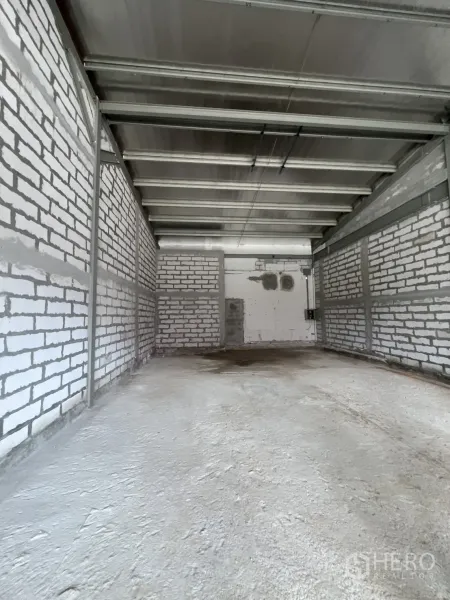 Retail Space for rent - Deep interior shell space with exposed steel beams, white brick walls and concrete floor