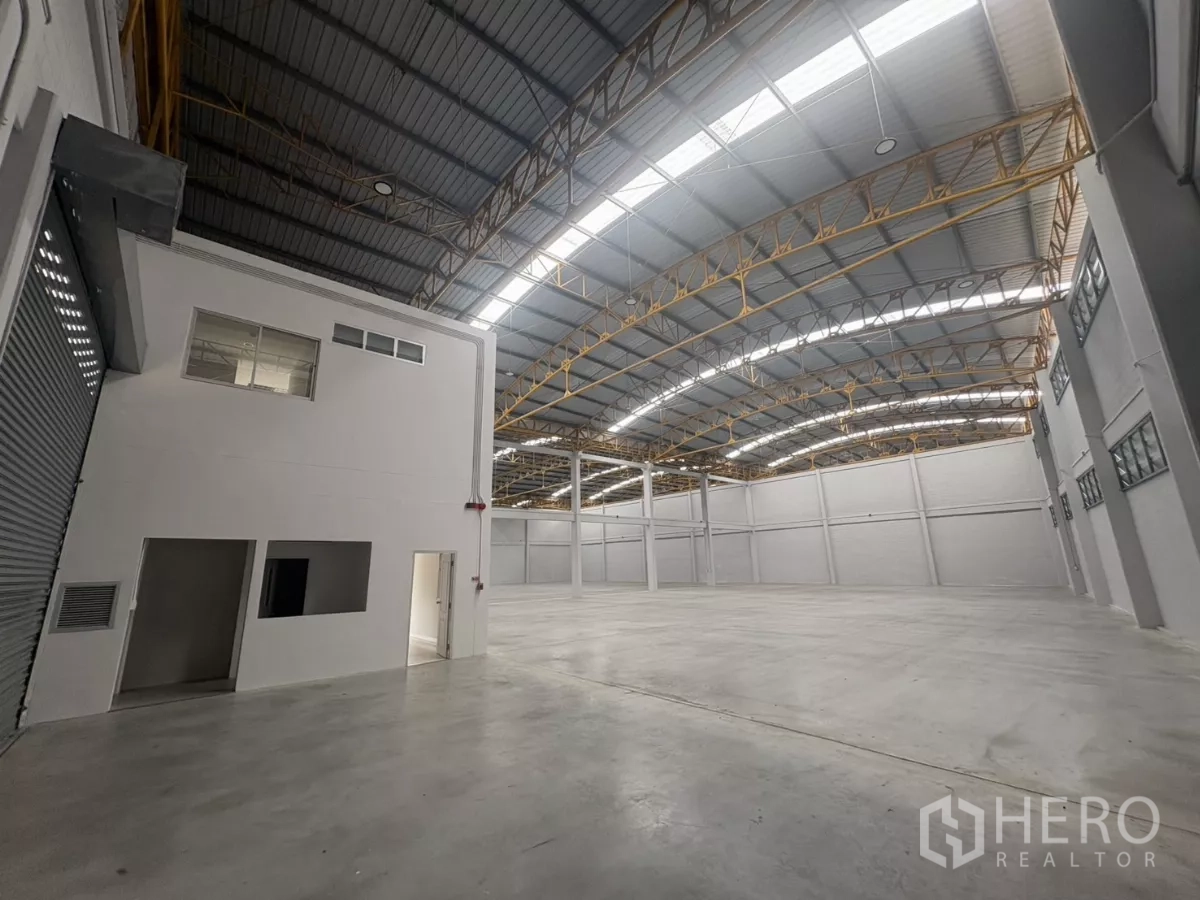Factory for rent in Bang Phli, Samut Prakan - Warehouse corner showing roller shutter and two-story office structure.
