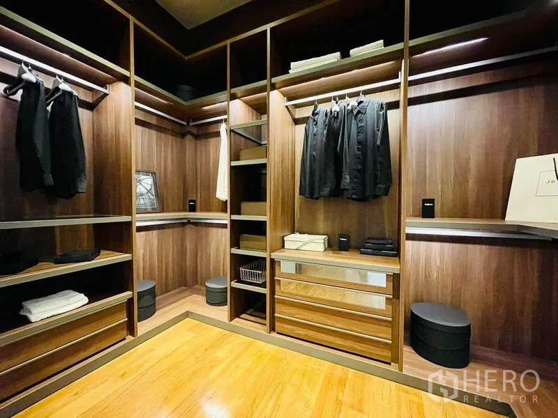 Condominium for sale in Pathum Wan, Bangkok - Large walk-in wardrobe with custom wood cabinetry, drawers and ample hanging space.