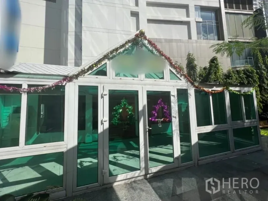 Retail Space for rent in Watthana, Bangkok - Glass-fronted retail pavilion with green-tinted windows and festive garland in a city courtyard