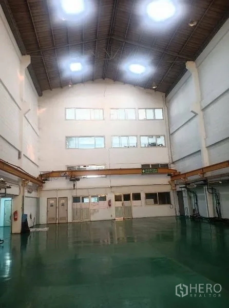Factory for sale in Khlong Luang, Pathum Thani - Spacious workshop with skylights, crane beam and polished green floor.