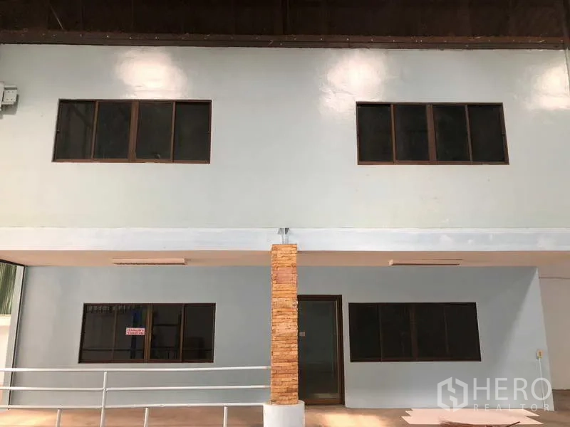 Warehouse for rent in Sai Noi, Nonthaburi - Front of the two-storey office section with brick-clad columns and windows.