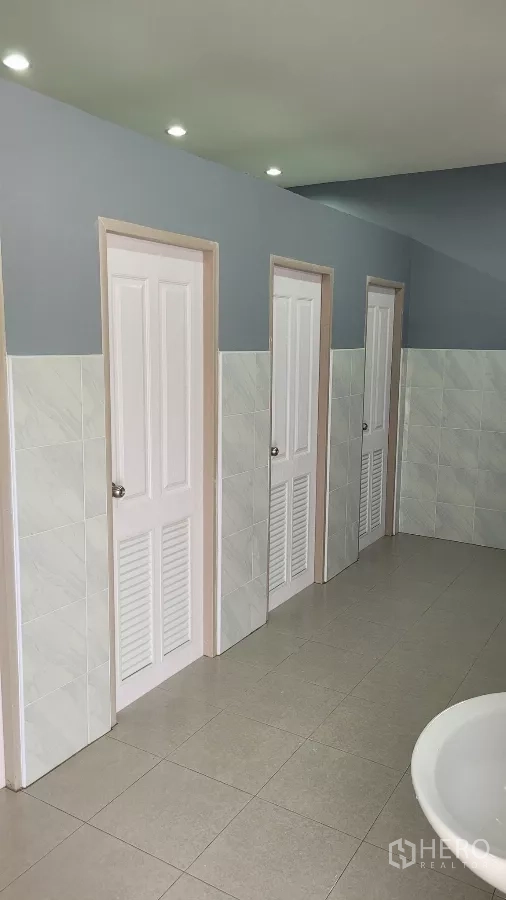 Factory for rent or sale in Phanat Nikhom, Chon Buri - Clean restroom area with multiple cubicle doors for staff.