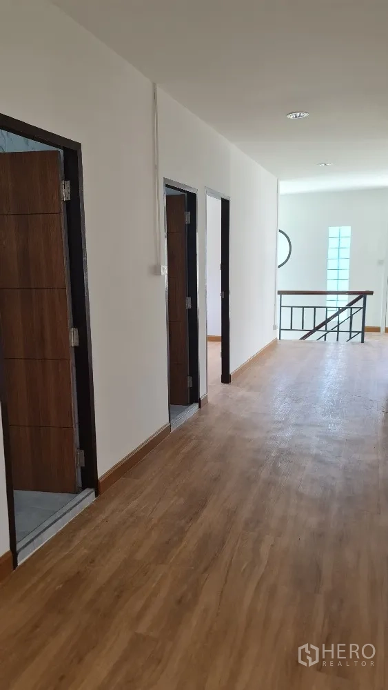 独栋房屋 for rent in Lat Phrao, Bangkok - 二层走廊铺木地板，沿走道分布多扇房门。