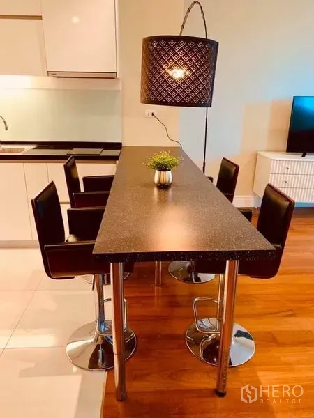 Condominium for rent in Khlong Toei, Bangkok - Slim dining island with four bar stools beside the open kitchen in a modern Bangkok condo.