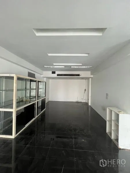 Retail Space for rent in Watthana, Bangkok - Open-plan retail interior with glossy black tile flooring, white walls, and recessed ceiling lights.