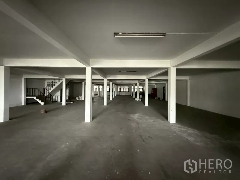 Shophouse for rent - Large upper-floor open area with columns and a side staircase.