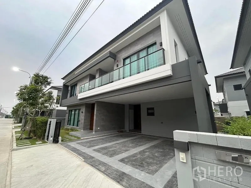 Detached House for rent in Bang Phli, Samut Prakan - Street view of the home showing wide driveway and balcony.