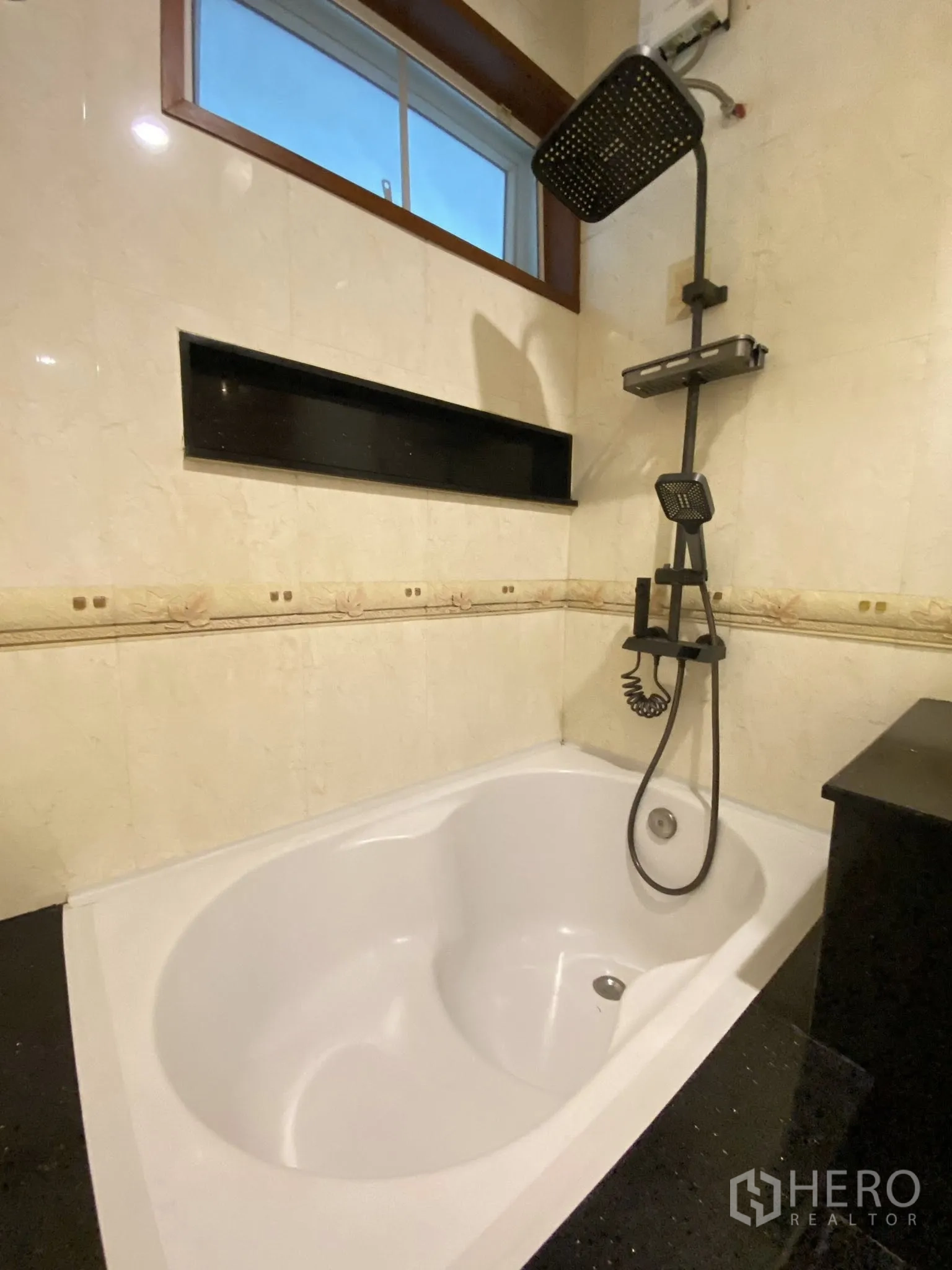 Home Office for rent in Pathum Wan, Bangkok - Bathroom with a deep soaking bathtub and rainfall shower beneath a window.