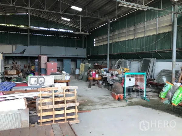 Warehouse for rent in Bang Phli, Samut Prakan - Open-plan warehouse bay with high ceiling, metal cladding, pallets and equipment arranged across wide floor area.