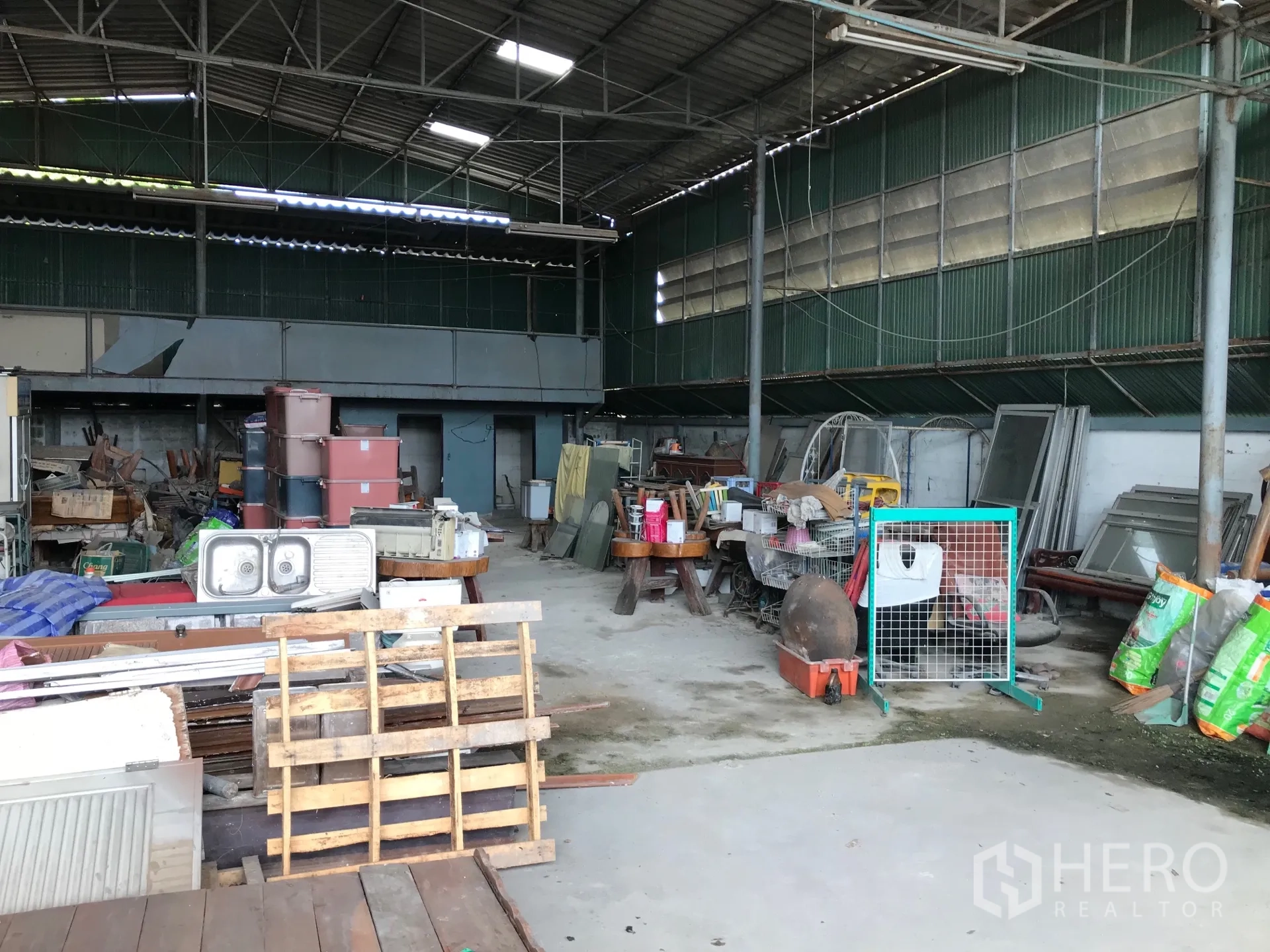 Warehouse for rent in Bang Phli, Samut Prakan - Open-plan warehouse bay with high ceiling, metal cladding, pallets and equipment arranged across wide floor area.