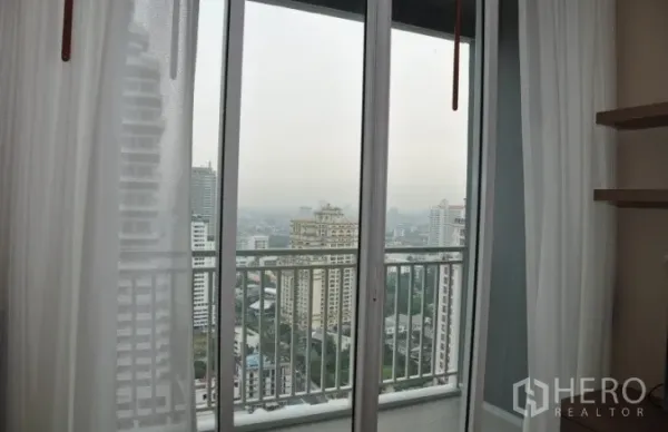 Condominium for rent or sale in Watthana, Bangkok - Sliding doors opening to a balcony with city skyline panorama.