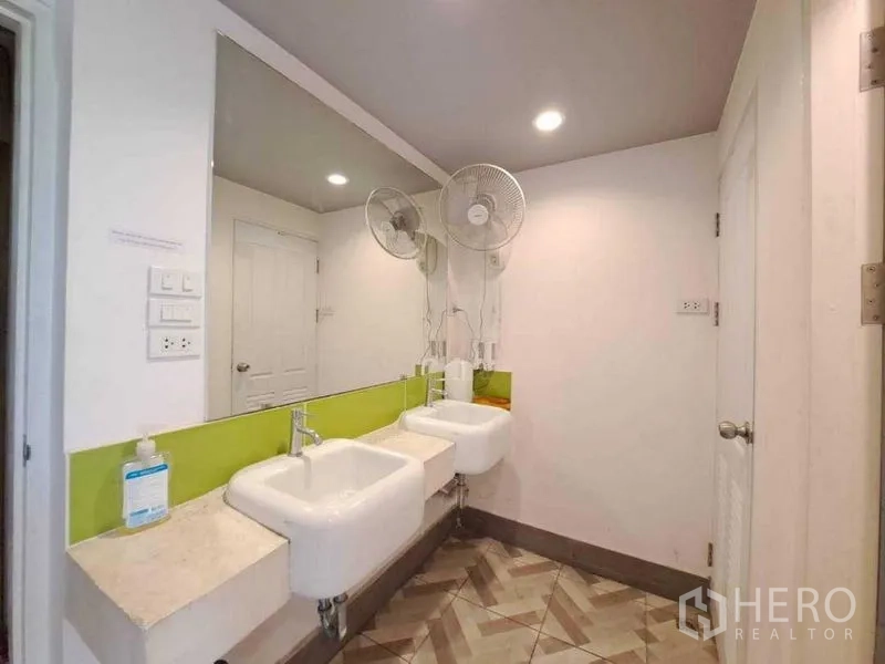Retail Space for rent in Khlong Toei, Bangkok - Clean restroom with double sinks, long wall mirror and recessed lighting.