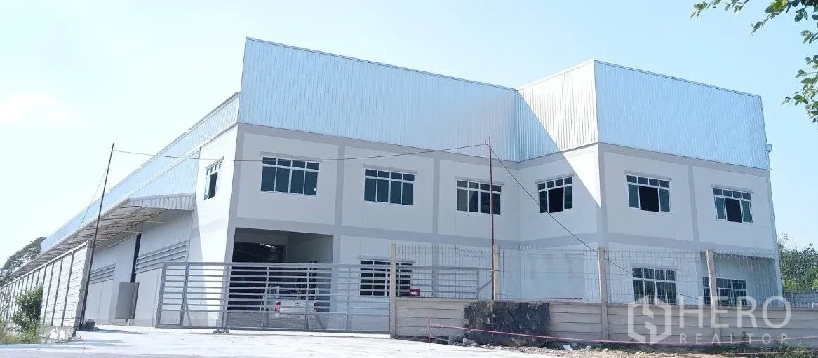 Warehouse for rent or sale in Lam Luk Ka, Pathum Thani - Modern two-storey warehouse with gated entrance and paved yard in Lam Luk Ka.
