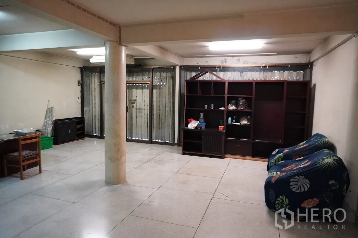 店屋 出租在Watthana, Bangkok - 临街店面大厅，立柱、金属推拉门与内置书柜。
