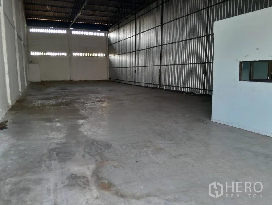 货栈 出租在Bang Phli, Samut Prakan - 宽阔仓库内部，波纹钢板墙及带窗的小型办公室区。