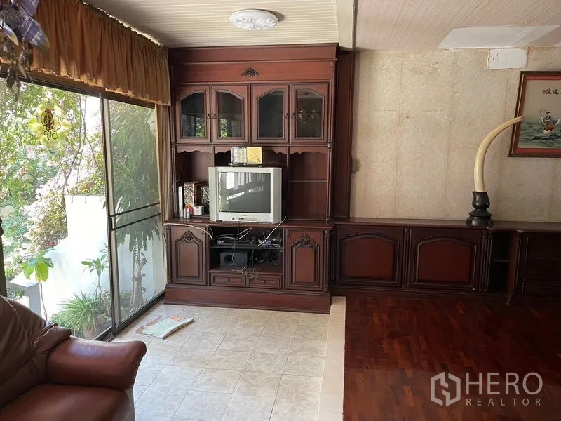 Home Office for rent in Watthana, Bangkok - Built-in TV cabinet beside balcony glazing and curtain in a sitting area.