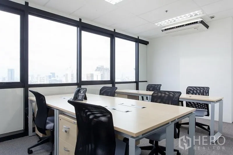 Office Space for rent in Khlong Toei, Bangkok - Bright office with multiple workstations beside large windows offering Bangkok city views.
