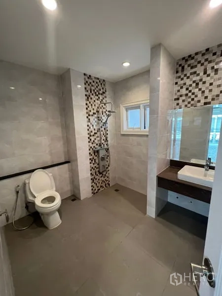 Home Office for rent - Modern bathroom with mosaic accent tiles, window, vanity sink, and shower area.
