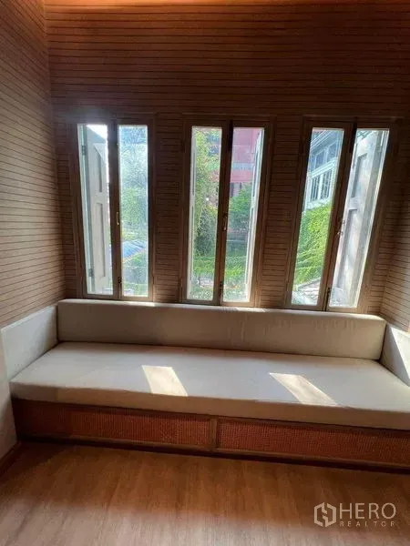 Retail Space for rent in Phaya Thai, Bangkok - Cozy built-in bench beneath tall vertical windows in a wood-clad room.
